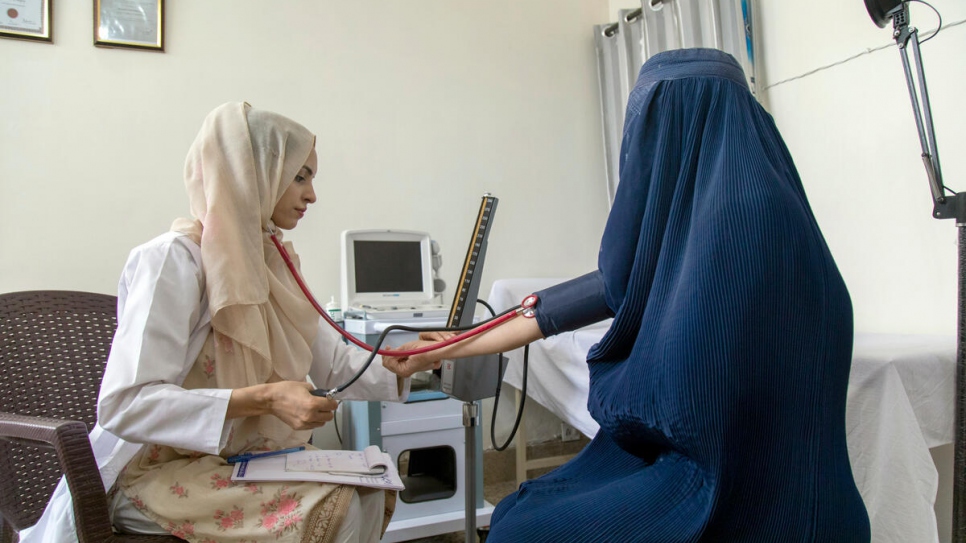 Saleema ausculte un patient dans sa clinique à Attock, au Pakistan.  