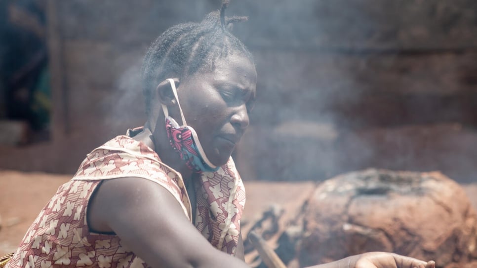 Elodie, a displaced Congolese woman, cooks outside her shelter in Beni, in north-eastern Democratic Republic of the Congo.