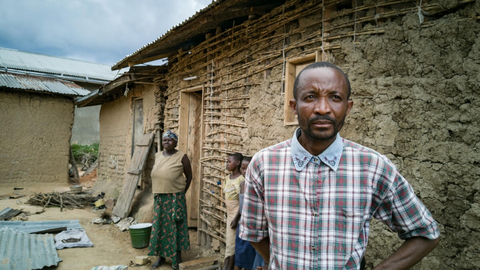 Evan Sikiani, a displaced Congolese man, stands outside the compound of his host, Kahambu Mwavuli (back), where up to 25 people live in Beni, in north-eastern Democratic Republic of the Congo.