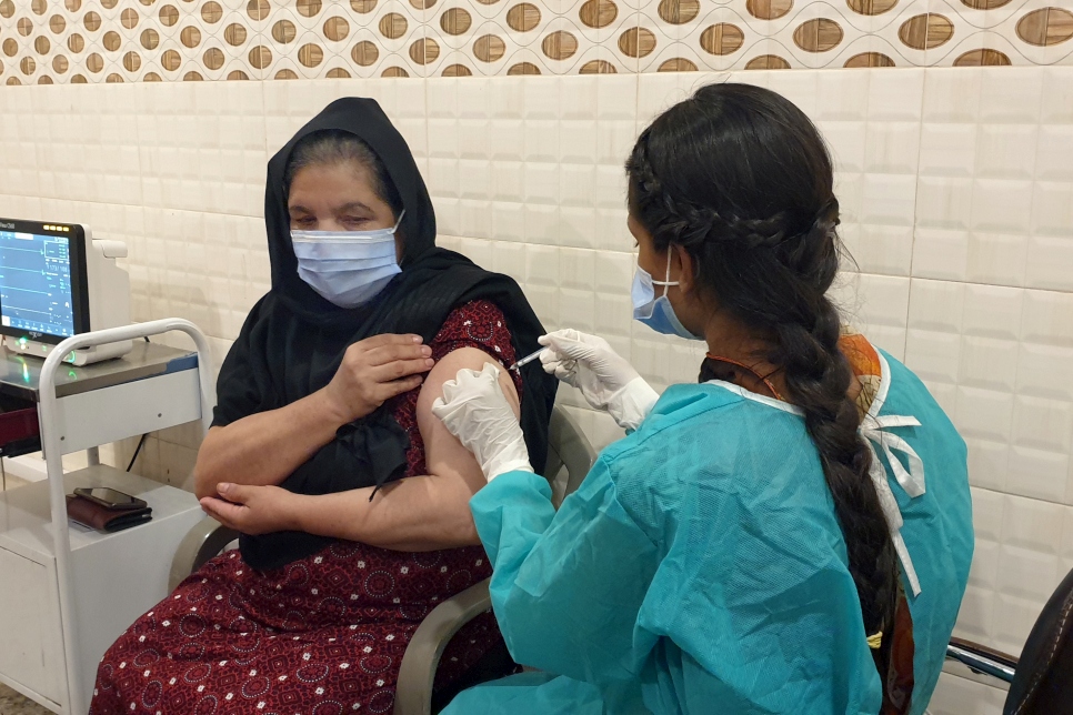 Nafisa, une réfugiée afghane de 48 ans, se fait vacciner contre le Covid-19 au centre de vaccination du Croissant-Rouge à Rawalpindi, au Pendjab.  