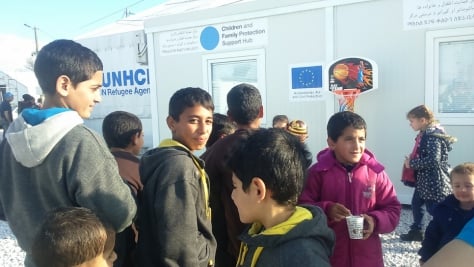 A group of children stand outside the Blue dot Children and Family Protection support centre.