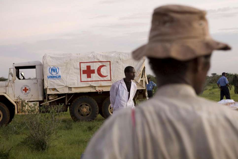 Kenya / Floods in Dadaab / Incentive workers and UNHCR staff collect items airdropped from american c130 planes at Dadaab refugee camps. Items dropped included plastic sheeting and mosquito nets. At the time of the airdrops Dadaab camps had been cut off from the world for more than 3 weeks due to heavily flooded roads in the area. / UNHCR / B. Bannon / 9 December 2006