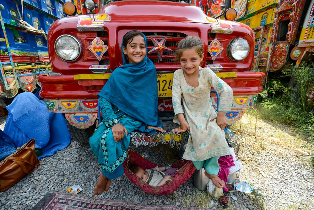 Sisters Salma, 10 and Saima 7, look after baby Moustafa while they wait to go to Afghanistan.