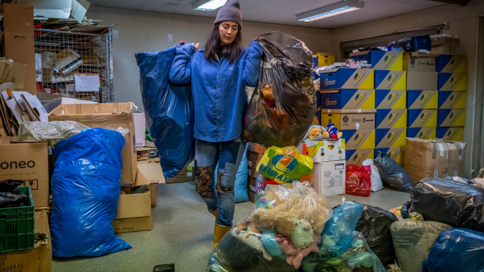 Agnieszka, who is affectionately called "Our Lady of Krakow" by visitors to the centre, sorts donated items for collection.