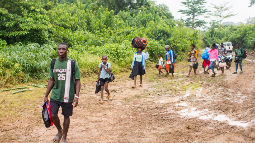 Des familles ivoiriennes parcourent la courte distance entre le camp de transit de Buutuo (Libéria) et la rive de la rivière Cestos avant de rentrer dans leur pays. 