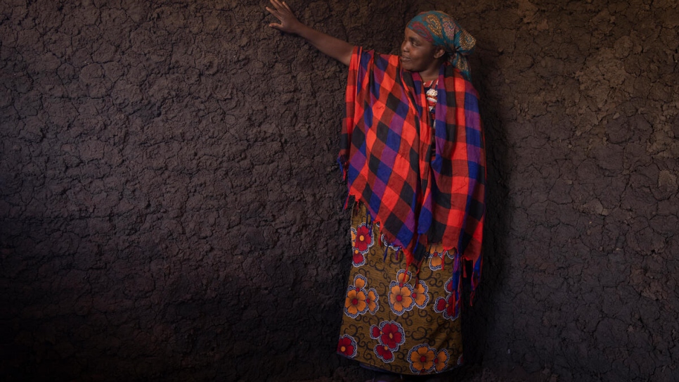 Patrício's wife, Anastasia Cristiano, checks the walls of the new home she helped build.