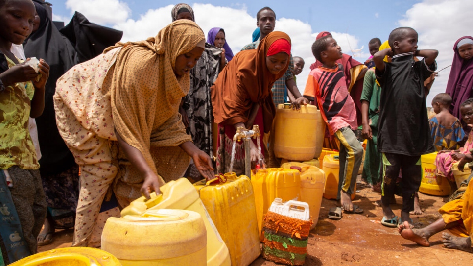 Des réfugiés récemment arrivés de Somalie font la queue pour recueillir de l'eau au camp de Dagahaley à Dadaab, au Kenya.