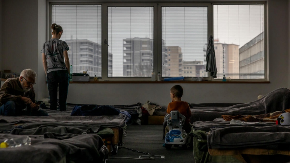 Arsen rides a toy car around the shelter where he lives with his parents and two siblings.
