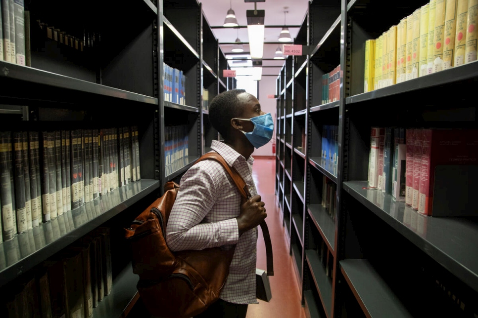 Jules, un estudiante de 26 años de la República Democrática del Congo, explora los estantes de la biblioteca de ciencias sociales de la Universidad de Florencia.