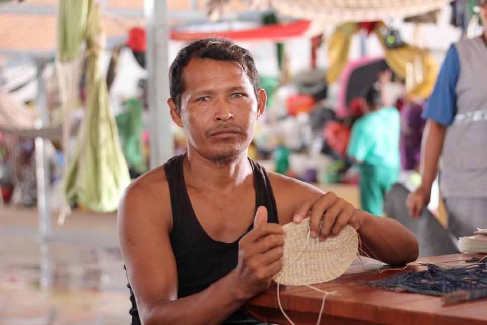 Baudilio Centeno teje una canasta en el albergue Pintolandia en Boa Vista, Brasil. Venía de Tamacuro con su familia y alrededor de 700 Waraos más cuando se acabaron la comida y la medicina.  