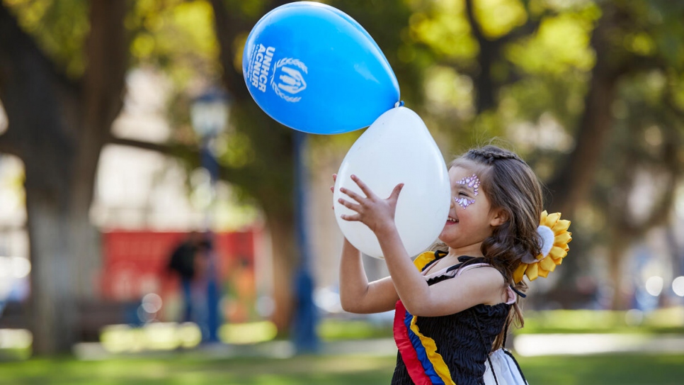 Une jeune réfugiée colombienne s'amuse avec des ballons après une randonnée à vélo à Mendoza, en Argentine.