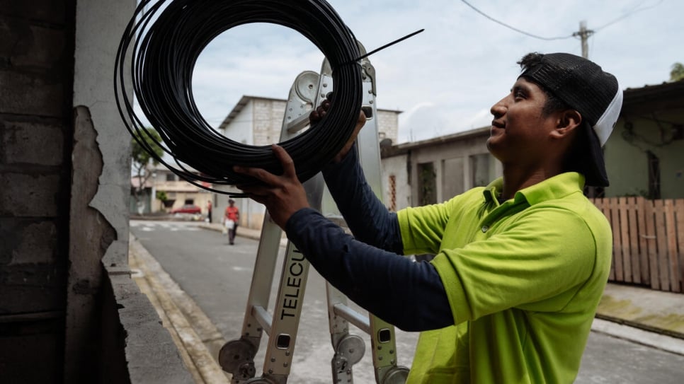 A Wayru staff member installs a router in Juan Montalvo. Each router can deliver internet to a 100 metre radius.