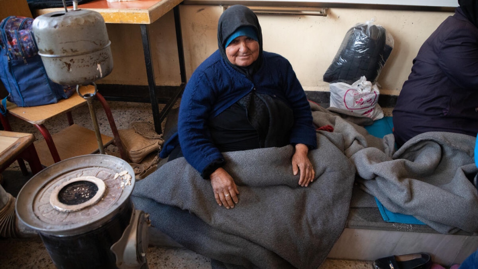 An elderly woman sits in the classroom of a school that has been turned into a collective shelter in the Salahadin neighbourhood of Aleppo, Syria.