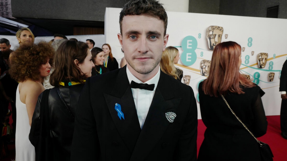 Actor Paul Mescal wearing a blue ribbon in solidarity with refugees at the EE BAFTA Film Awards 2023.