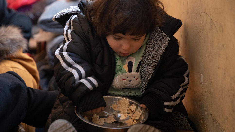 A young girl eats some bread at the school in Salahadin neighbourhood, which now hosts dozens of families from Aleppo displaced by the earthquakes.