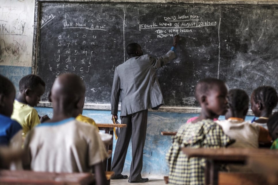 "Fewer girls go to school here because of early marriage. Sometimes their family situation forces girls to stay at home to prepare food or make tea to sell."

South Sudanese refugee teacher, James Tut, teaches a class at the primary school in Jewi camp, Ethiopia.