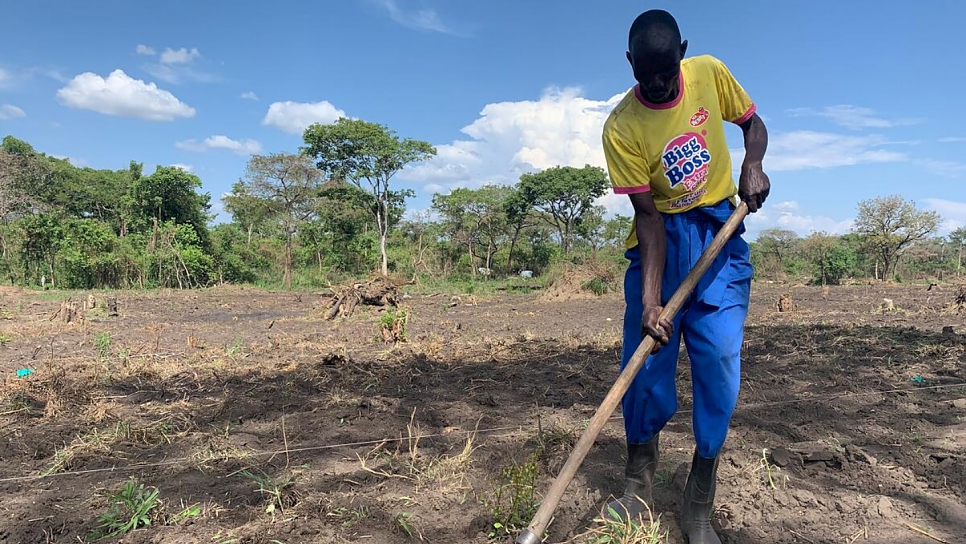 Odong Anthony digs the soil on land cultivated by the Can-Coya farming collective.