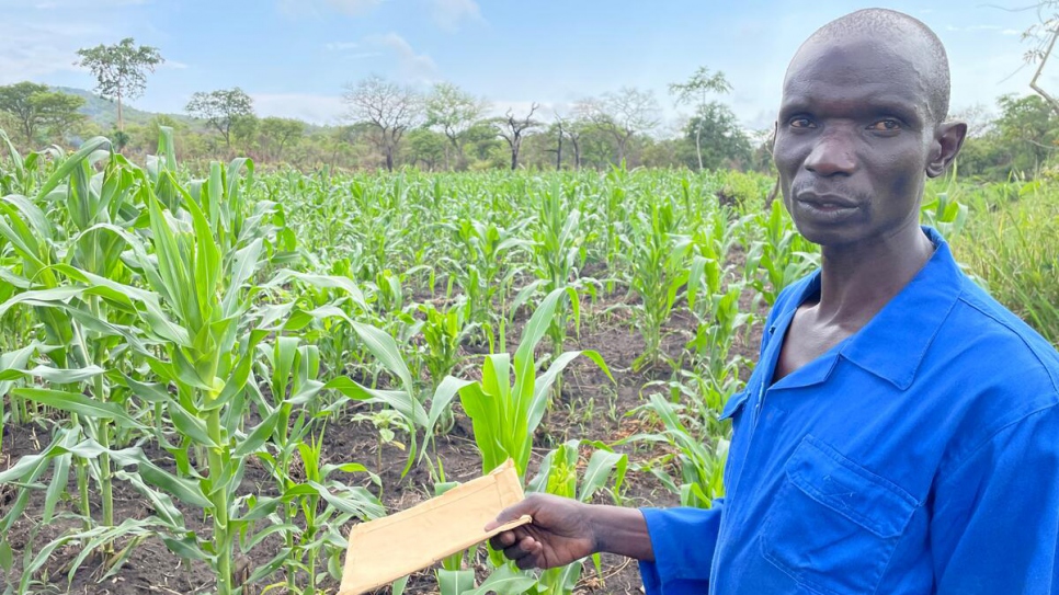 Odong Anthony stands in a field of corn growing on lands planted by the Can-Coya farming collective, of which he is chairman.
