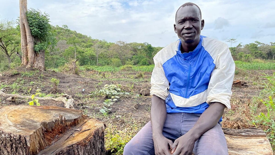 Returned refugee Mwaka Paul, 33, takes a break from clearing the land for planting.