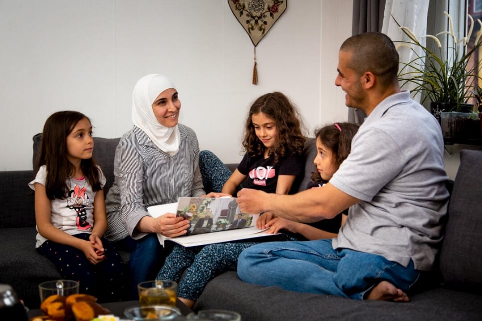 The family - Hanan and Ali and their children Amina, Sara and Youmna - look through one of their photo albums together.