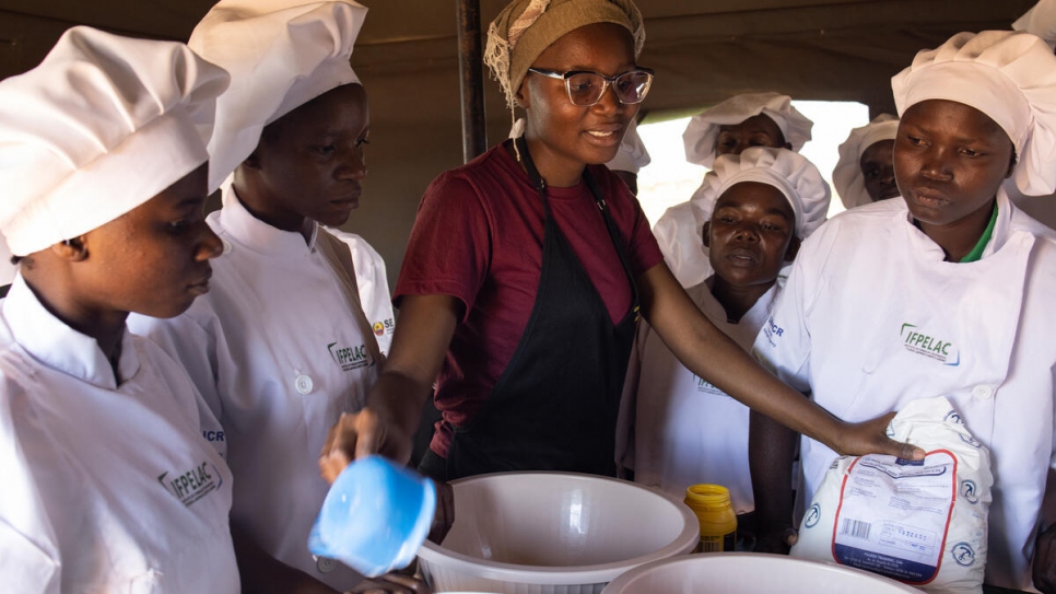 Helena Marcia Cesarito (red shirt), 24, is a trainer from from UNHCR partner IFPELAC who offers cooking classes for displaced and local people. 