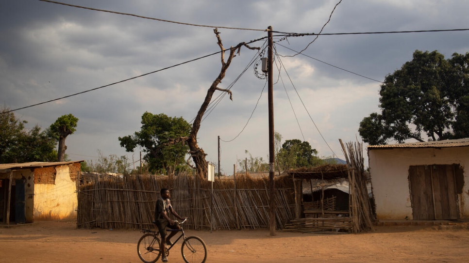 A man rides a bike near an electricity pole in Maratane settlement, home to some 9,200 refugees, mainly from the Democratic Republic of the Congo and Burundi.