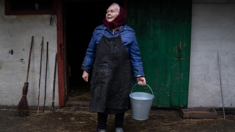 Kateryna carries milk from the family's dairy cow, which she was reluctant to abandon during the worst of the fighting.