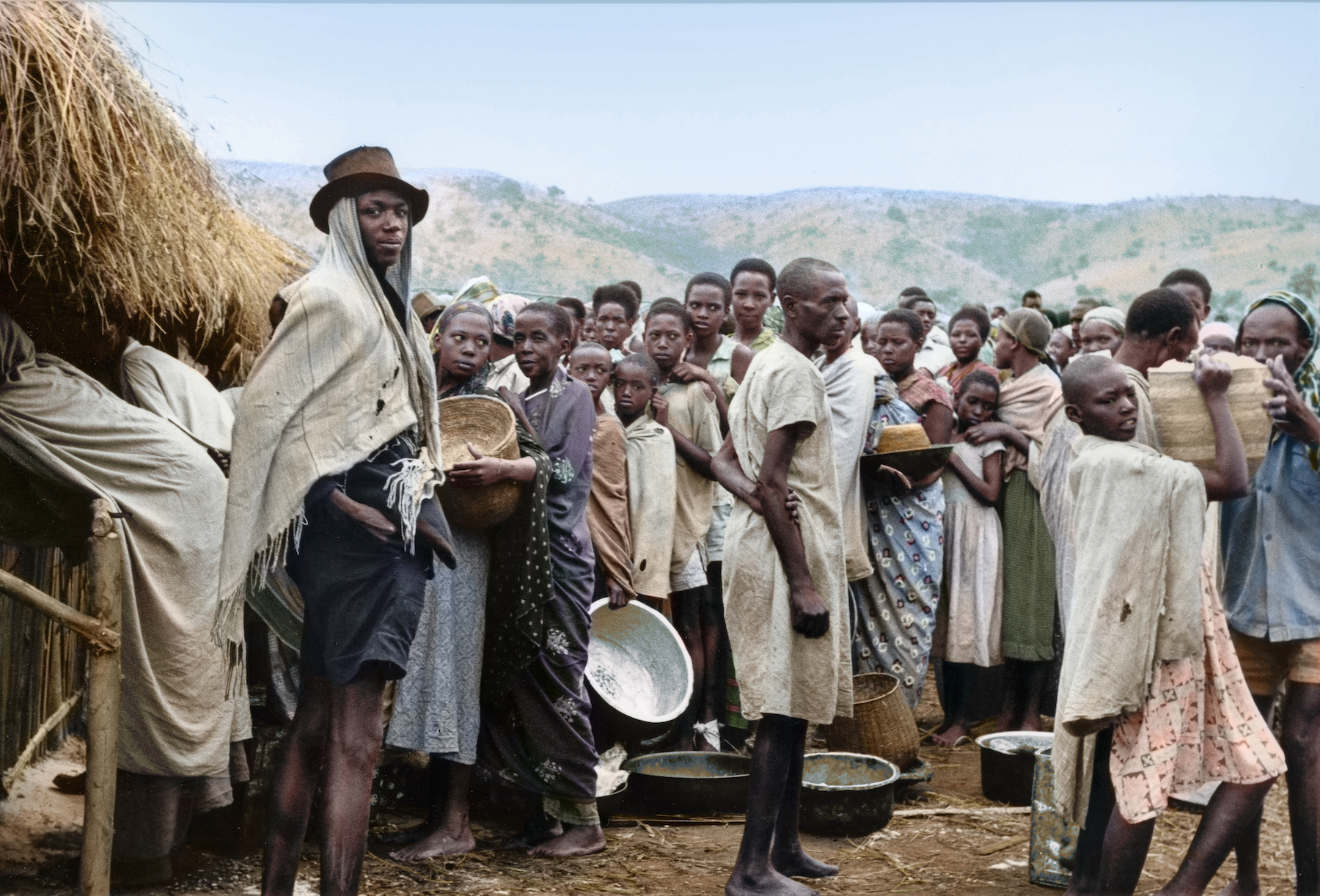 A group of Rwandese waiting for the distribution of food rations at a refugee centre in Uganda's Oruchinga Valley, 1964. Colorized picture
