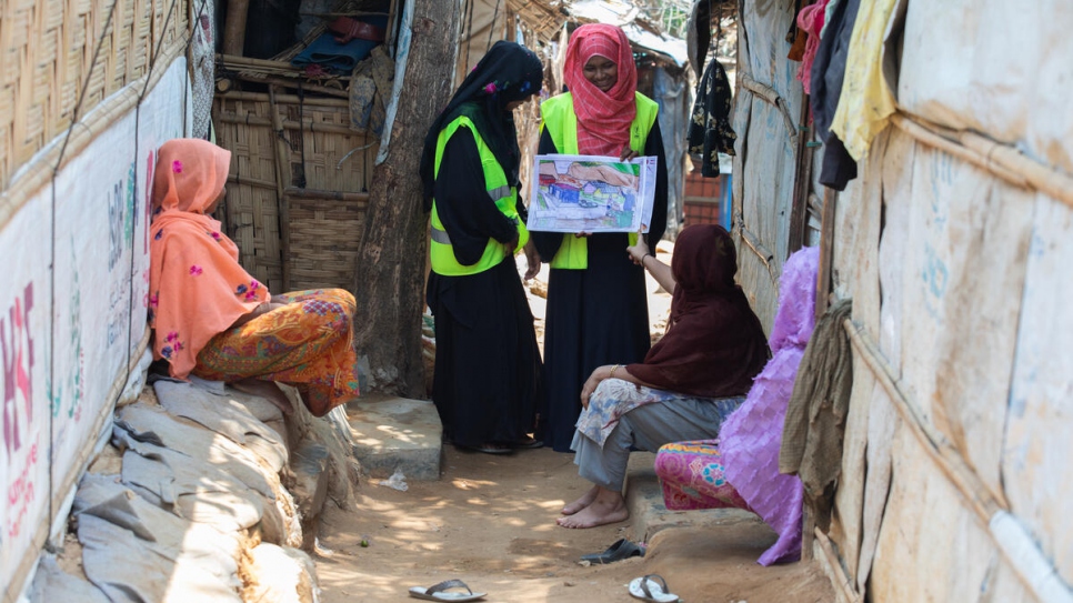 Members of one of the youth groups use posters to explain to other refugees how to properly dispose of their waste.