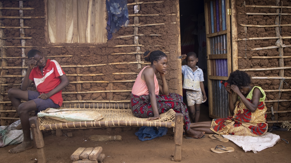 A family rest outside of their new home in Corrane site for displaced persons. 