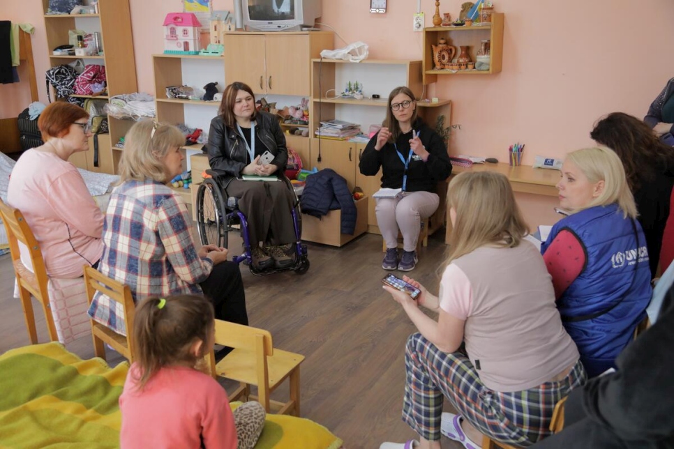 Tetiana and UNHCR staff meet with displaced people, some of them with mobility issues, at a rehabilitation centre for people with disabilities in the city of Svalyava in Zakarpattia Oblast.