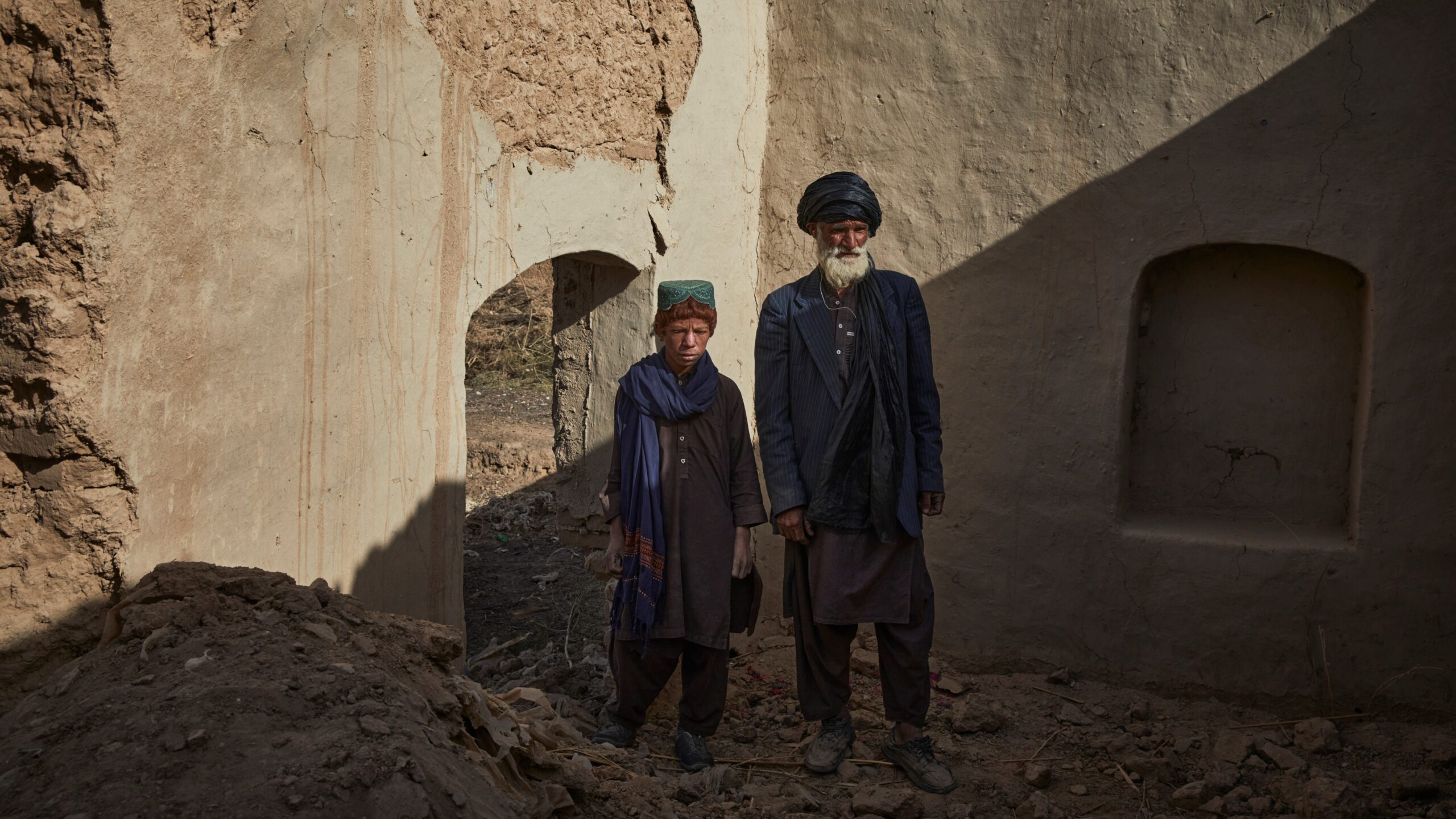 Sayed Mohammad en zijn zoon in hun beschadigde huis in Marja. © UNHCR/Andrew McConnell