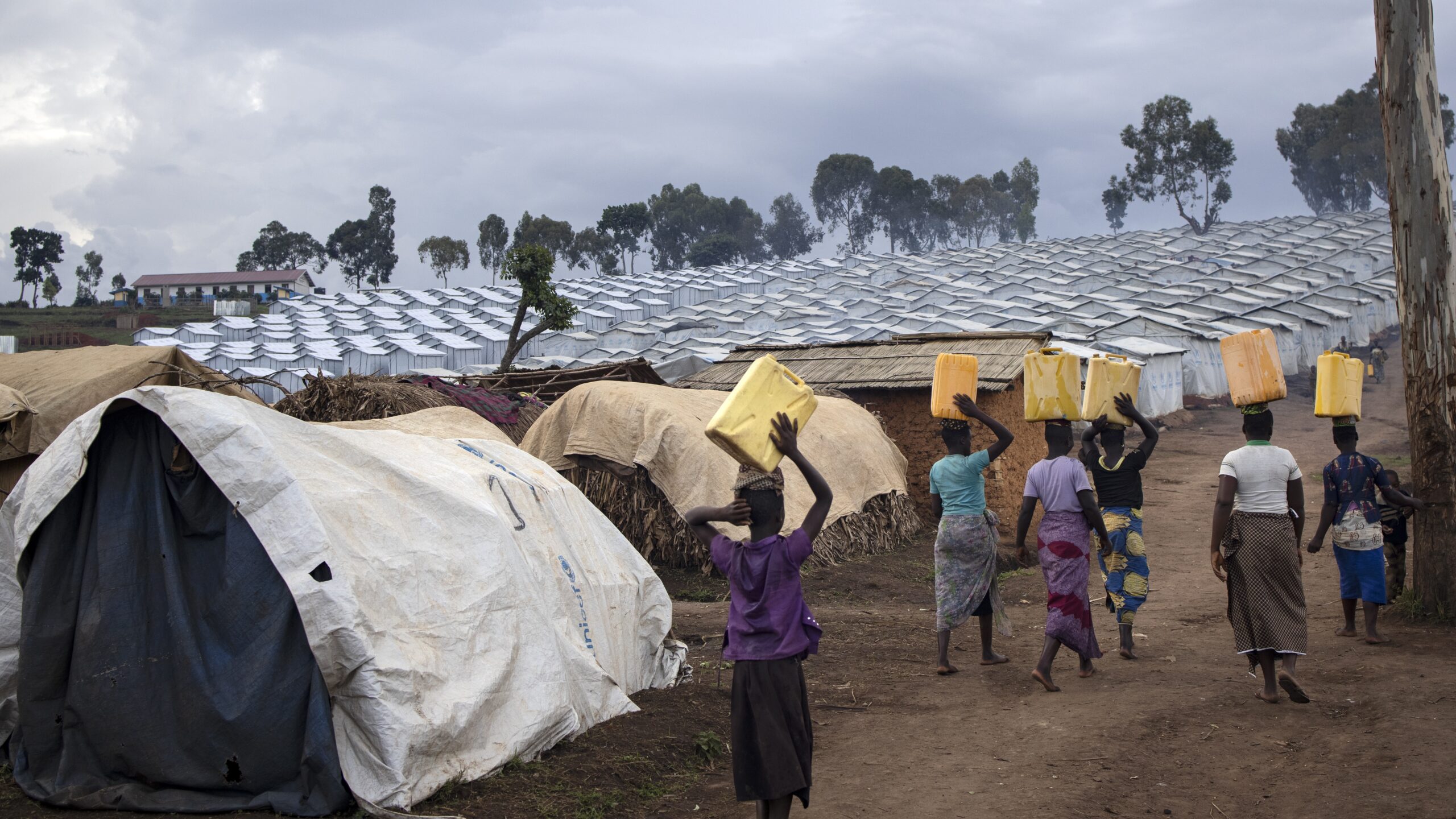 Vrouwen keren terug naar het Plaine Savo-kamp voor intern ontheemden in Ituri nadat ze water hebben gehaald. © UNHCR/Hélène Caux