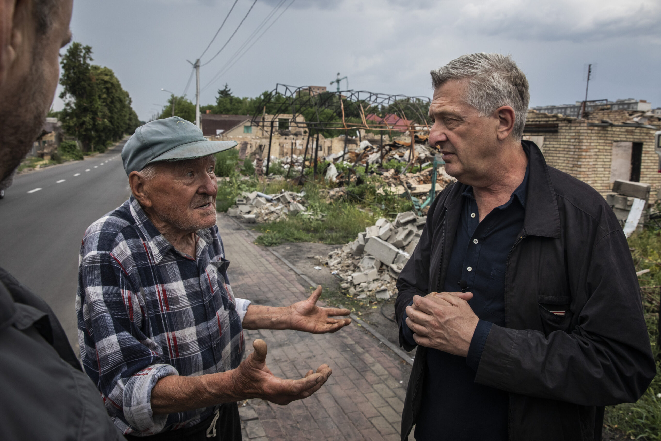 VN Hoge Commissaris voor de vluchtelingen ontmoet de 85-jarige Grygoryi in een verwoeste wijk in Boetsja, juli 2022. © UNHCR / Andrew McConnell