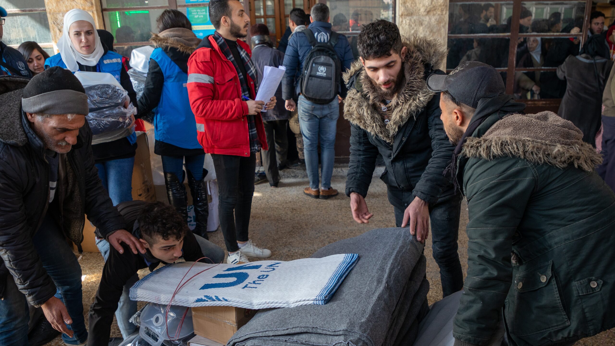 Hulpgoederen worden uitgedeeld aan families die verblijven in de moskee in de Suleiman al-Halabiwijk in Aleppo, Syrië, op 8 februari 2023. © UNHCR/Hameed Maarouf