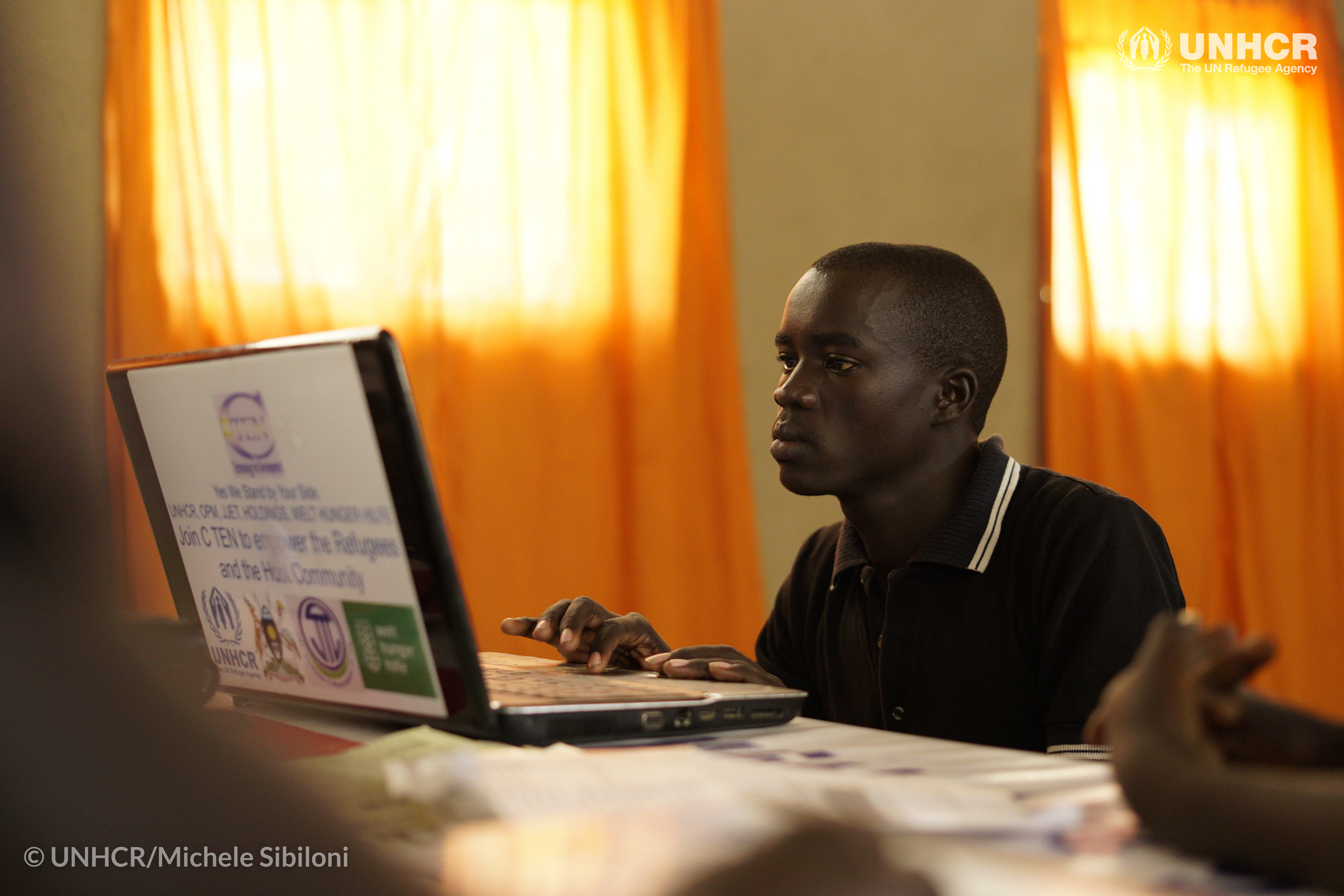 Maliamungu Richard, 23, een vluchteling uit Zuid-Soedan die in Uganda woont, is mede-oprichter van CTEN, een platform dat Zuid-Soedanese vluchtelingen in staat stelt contact te houden met hun familieleden in Zuid-Soudan en tegelijkertijd meer over computers te leren. ©UNHCR/Michele Sibiloni
