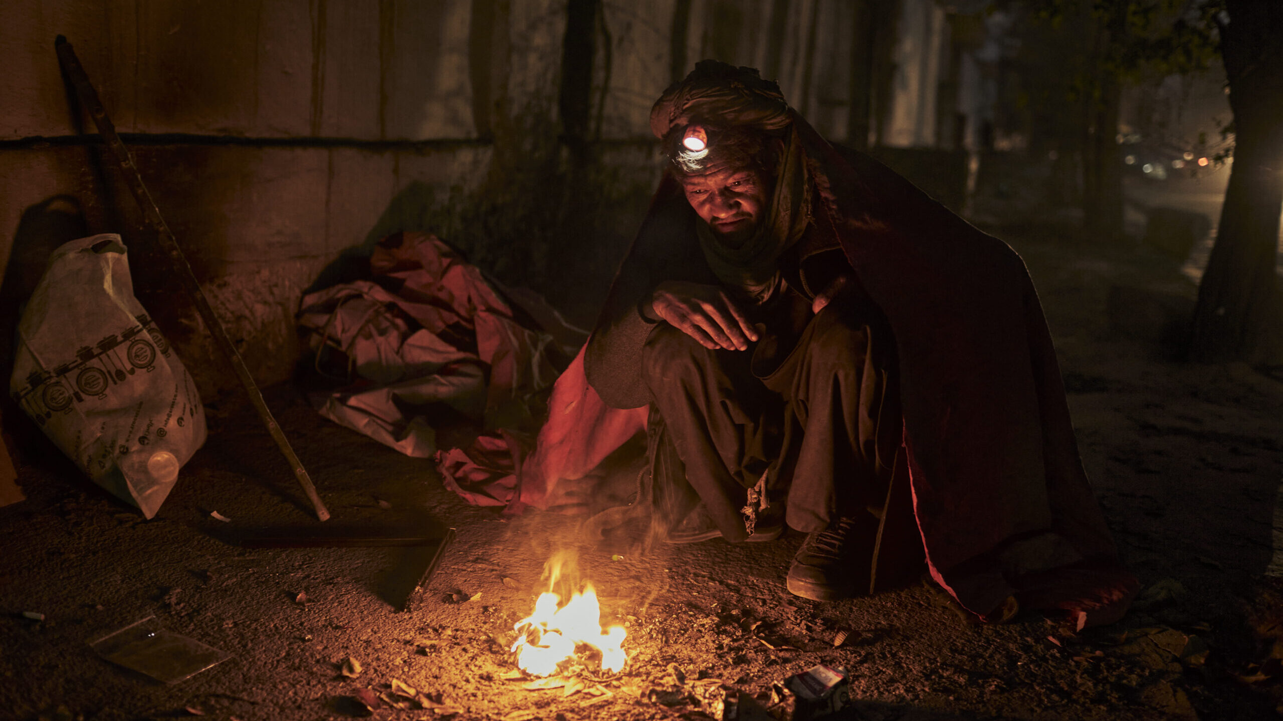 Een dakloze man probeert zich te verwarmen aan een klein vuurtje in de straten van Kabul, Afghanistan. © UNHCR/Andrew McConnell