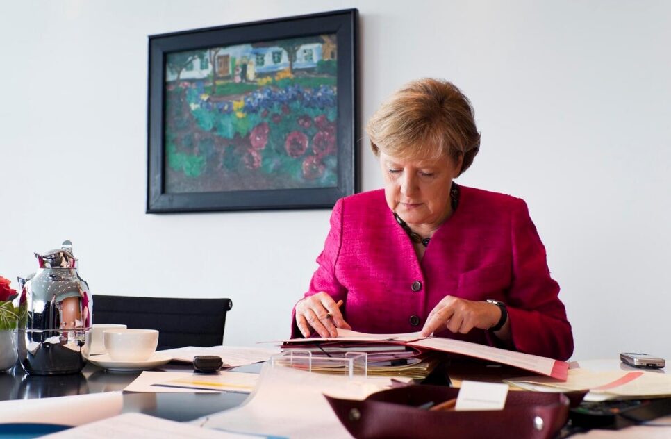 '2011 年，時任德國聯邦總理安吉拉·默克爾博士在她位於柏林聯邦總理府大樓的辦公室工作。© UNHCR/Steffen Kugler