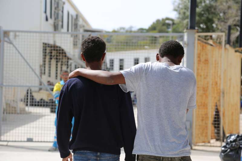 These two rescued men wait at a reception centre in Lampedusa for news of friends and relatives in need of medical treatment. 