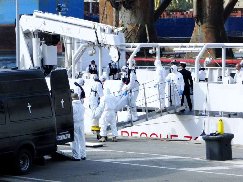 Emergency workers on a Maltese Coastguard vessel carry away the bodies of people who drowned off southern Italy's Lampedusa Island at the weekend.  