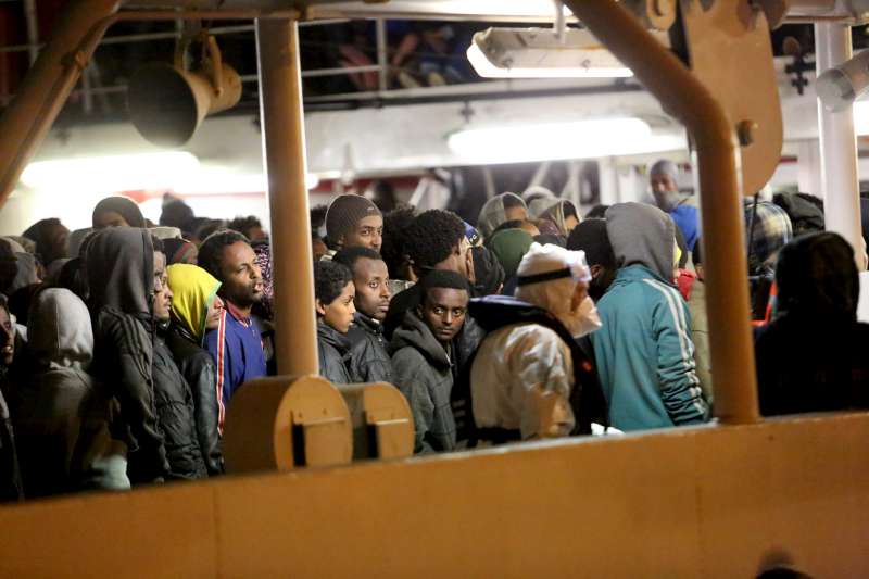 Rescued refugees and migrants wait to leave an Italian Coastguard vessel in Palermo, Italy. 