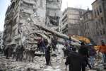 Rescue teams search for survivors in the ruins of a building in the Al...