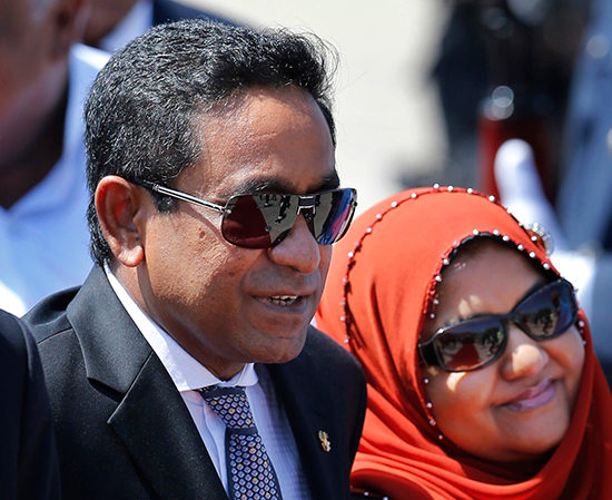 Maldivian President Yameen Abdul Gayoom (left) arrives in Sri Lanka in this January 12, 2014, file photo. Police raided the office of the Maldives Independent on September 7 after its editor was interviewed in an Al-Jazeera documentary alleging corruption and abuse of power under Gayoom's government, allegations his government has denied.