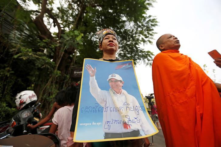 Supporters of Kem Sokha, former opposition leader and ex-president of the now-dissolved Cambodia National Rescue Party (CNRP), hold up a poster near the Appeal Court in Phnom Penh, Cambodia on March 27, 2018.