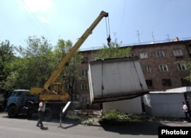 City workers dismantle a kiosk in Yerevan on August 10.