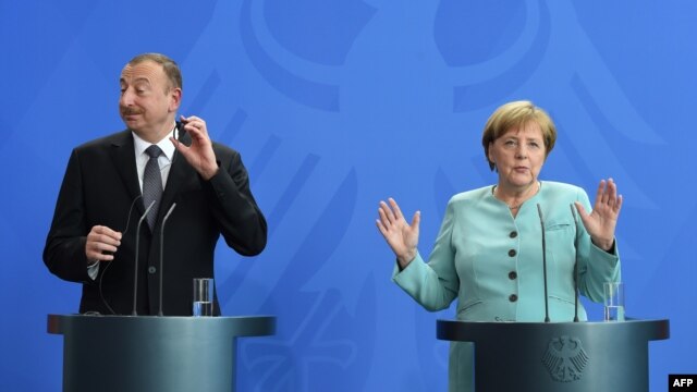 Azerbaijani President Ilham Aliyev (left) and German Chancellor Angela Merkel attend a press conference following their meeting at the Chancellery in Berlin on June 7.