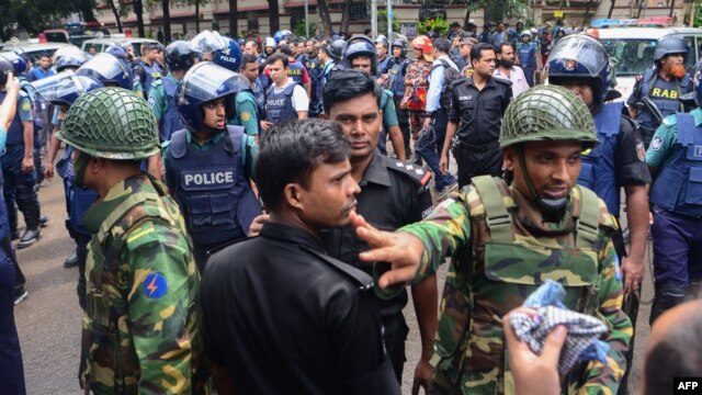 Bangladeshi police and military gather in an intersection near an upscale restaurant after a bloody siege ended in Dhaka on July 2.