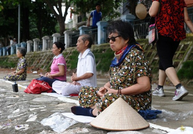 Followers practice Falun Gong by the side of a lake in Hanoi, May 8, 2013.