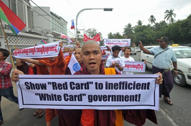 A Buddhist monk chants slogans as he holds a banner protesting a law which grants voting rights to temporary citizens in Yangon, Feb. 11, 2015.