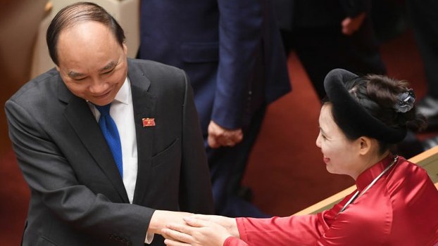 Vietnam's Prime Minister Prime Minister Nguyen Xuan Phuc (L) is greeted by a deputy prior to the opening of the annual summer session of the National Assembly in Hanoi, May 22, 2017.